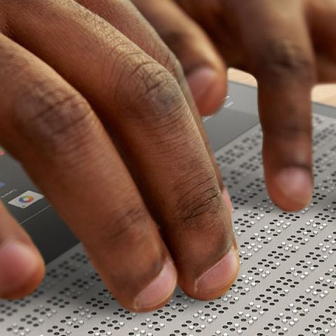 SE observan unas manos en primer plano leyendo en Braille haciendo referencia a la accesibilidad y su importancia para la inclusión social.