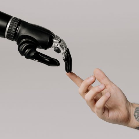 imagen ilustrativa Se muestra una mano robótica haciendo contacto con una mano humana