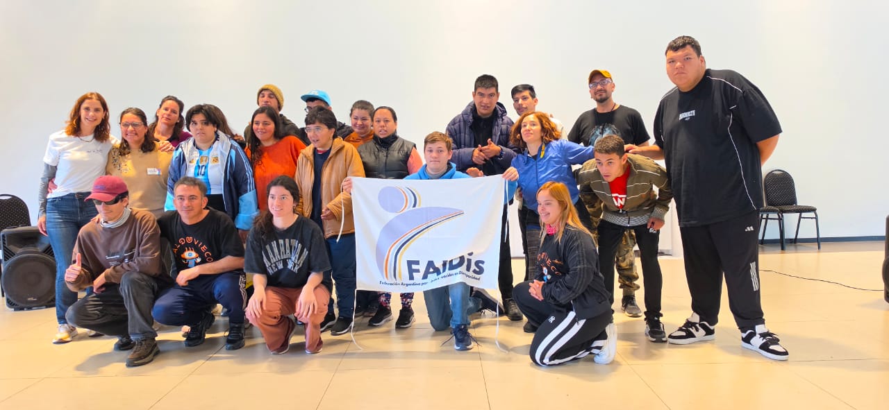 Grupo de personas con y sin discapacidad co la bandera de Faidis adelante